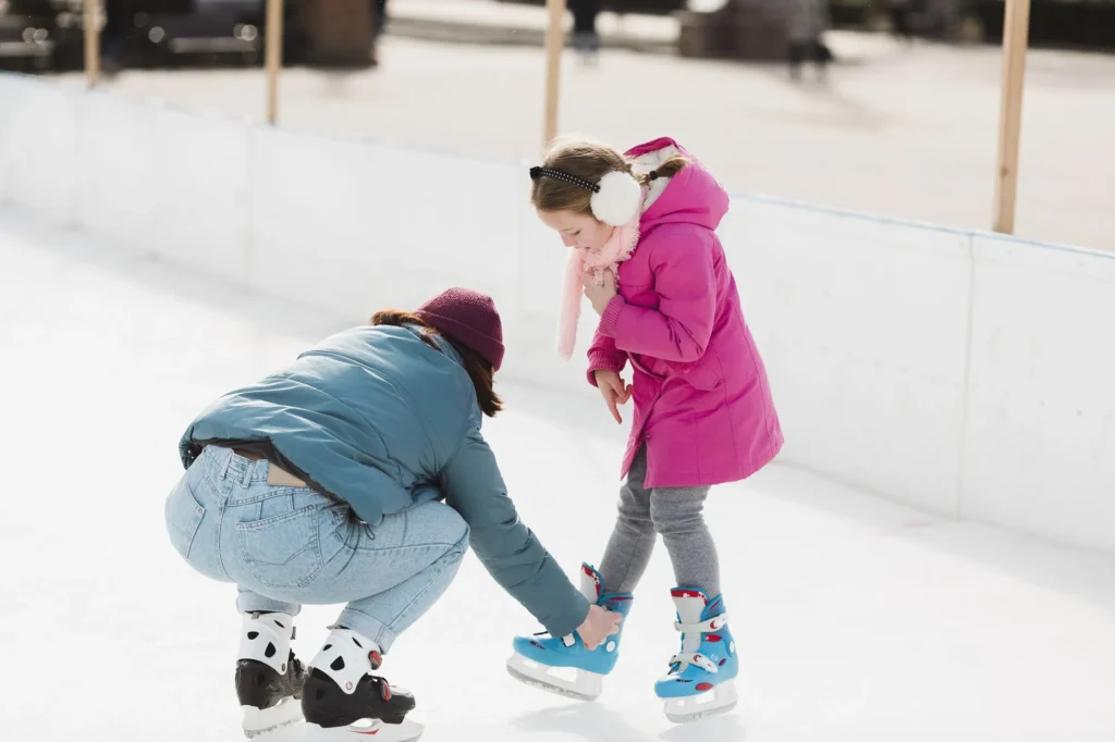 In the image, a young woman and a little girl at the ice rink.