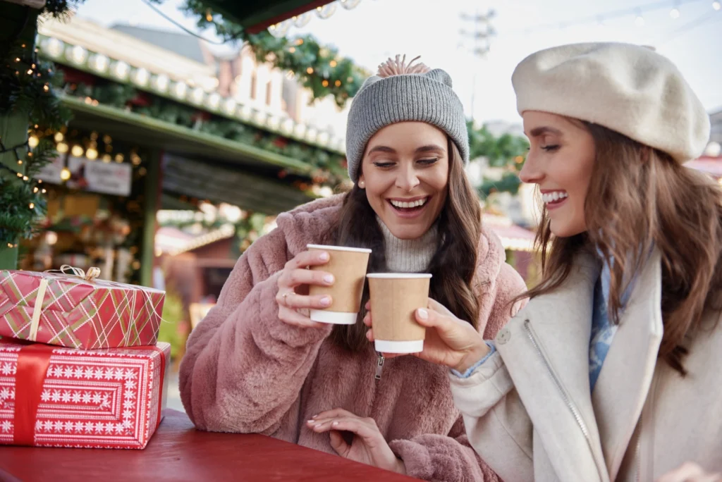 In the image, two friends at the Christmas markets