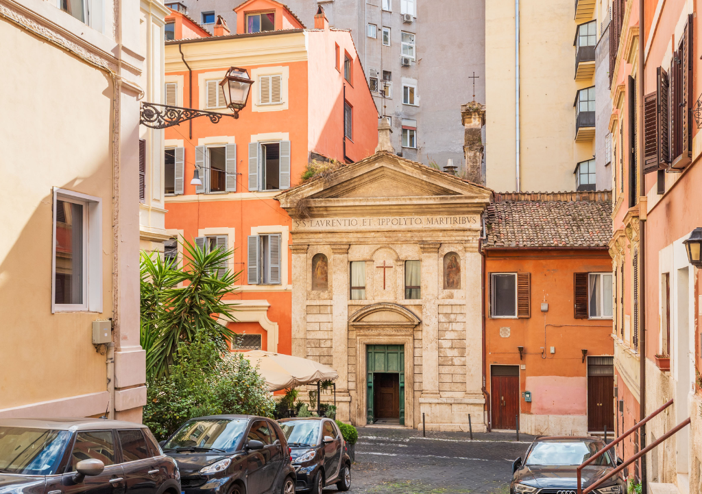 L'immagine rappresenta uno scorcio di Via Urbana, con palazzi colorati misti tra moderni e antichi.