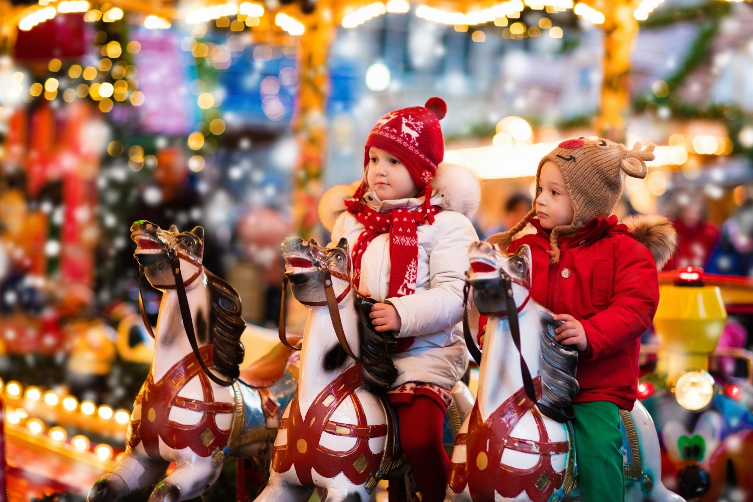 l'immagine rappresenta 2 bambini sui cavalli della storica giostra di Natale che viene allestita in Piazza Navona.