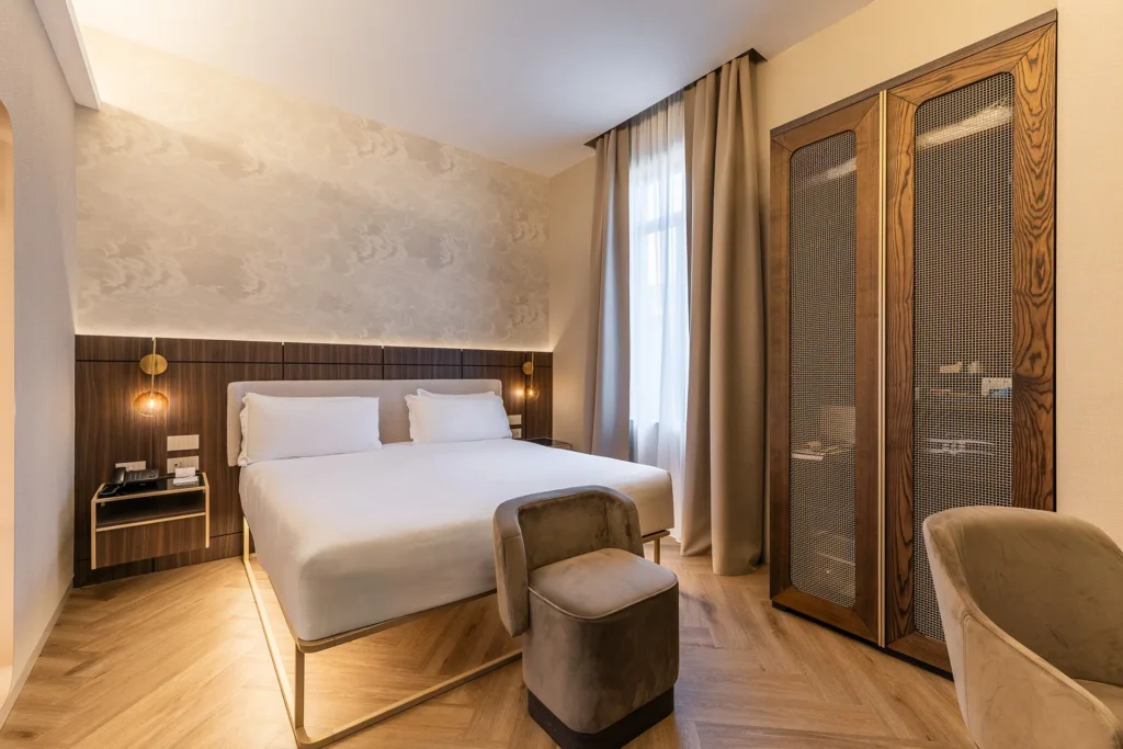 Camera matrimoniale rinnovata dal design moderno dell’Hotel Raffaello con arredi eleganti, armadio in legno e luce naturale