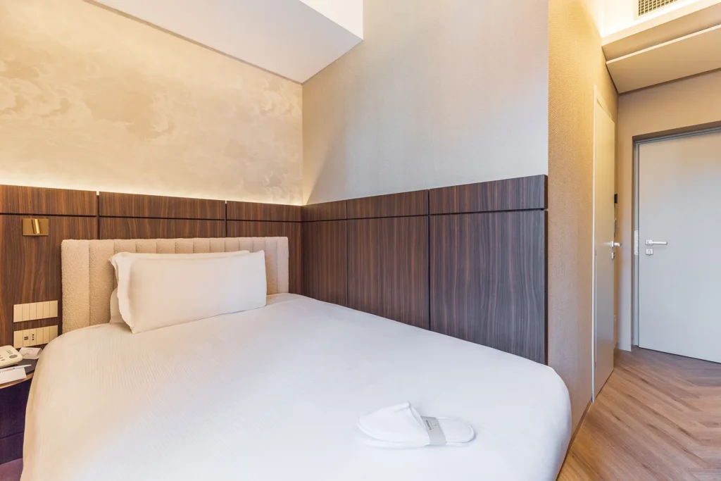 Camera matrimoniale rinnovata dal design moderno dell’Hotel Raffaello con arredi in legno e illuminazione soffusa
